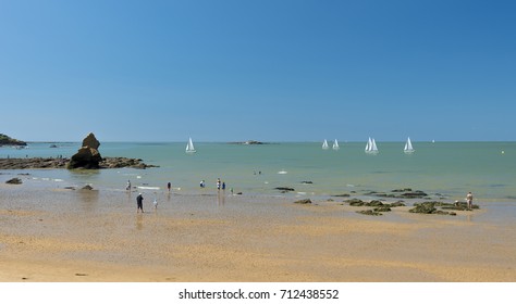 Sailing Boats Glide By On A Hot Summer Day At A South Brittany Beach In The Gulf Of Morbihan,