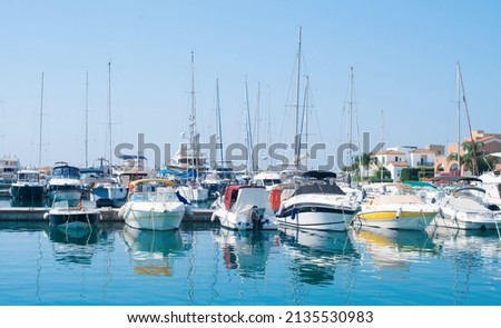 Sailing Boats and Motor Boats moored at Marina in Cyprus with residential houses on the background. Yacht harbor.