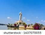 sailing by the buddha statue with pink bougainvillea plants in the middle of hussain sagar lake in Hyderabad, Telengana, India.