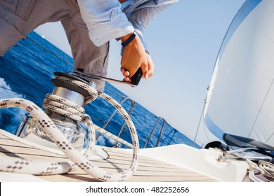 Sailing Crew Member Pulling Rope On Sailboat
