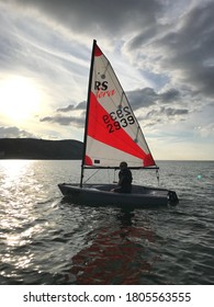 Sailing Dinghy On Calm Water At Sunset