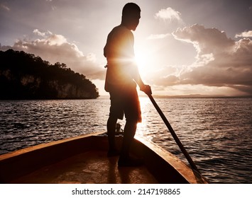 Sailing to a new adventure. Shot of a young man rowing a boat along the sea.