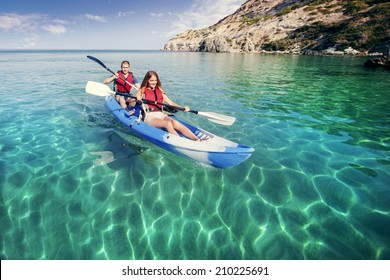 Sailing On The Sea Kayaking. Young Happy Couple Traveling By Kayak. Activities On The Water. 