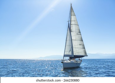 Sailing ship yachts with white sails in the open Sea. Luxury boats.