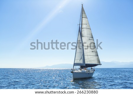 Sailing ship yachts with white sails in the open Sea. Luxury boats.