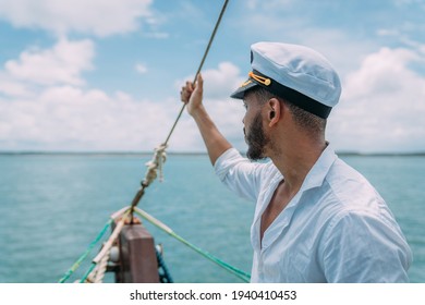 Sailing sport. Captain in charge. Latin american man with ship captain's hat.