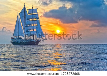 Sailing yacht on the background of a beautiful sunset in the sea
