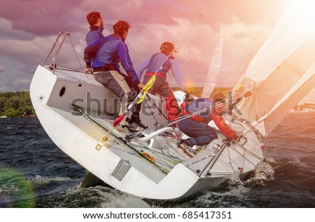 Sailing yacht race, regatta. Sail boat. Team athletes participating in the sailing competition. Recreational Water Sports. Extreme Sport Action. Healthy Active Lifestyle. Summer Fun Adventure