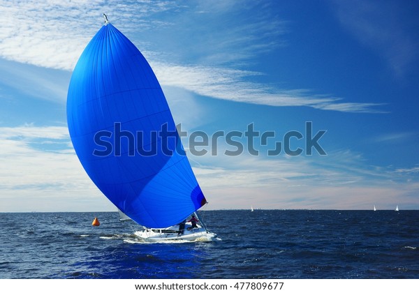 Sailing yacht race. Yachting. Boat with big blue\
spinnaker sail.