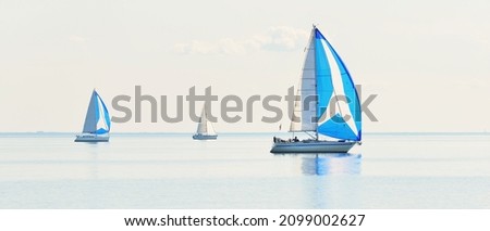 Sailing yacht regatta. Modern sailboats racing with blue spinnaker sails. Clear summer day. Kiel, Germany. Sport and recreation, transportation, private wessel, vacations