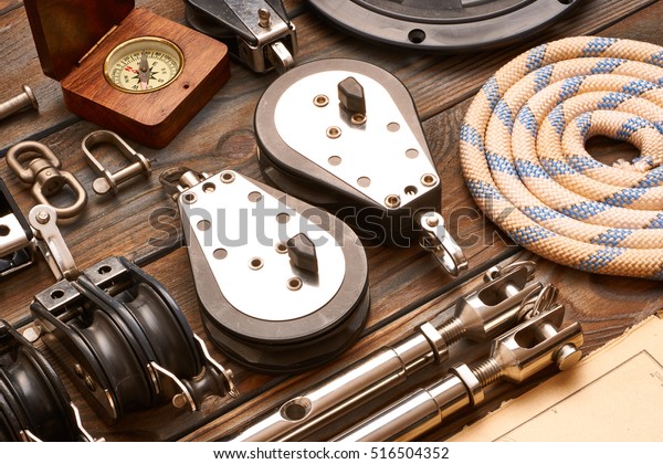 Sailing\
yacht rigging equipment on wooden background\
