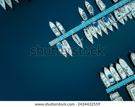 Sailing yachts moored in marina aerial view from drone. Blue sea water. Mediterranean yacht port with sailing boats. Yachting concept