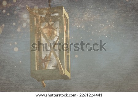 A sailor lamp made of wood and nautical objects with gold lights, bokeh particles, silver blue color background. Copy space.