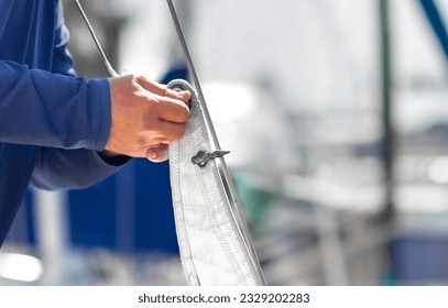 A sailor puts on sails on a yacht for a sea trip. Preparing the ship for the cruise. - Powered by Shutterstock