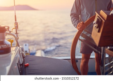 Sailor Using Wheel To Steer Rudder On A Sailing Boat.