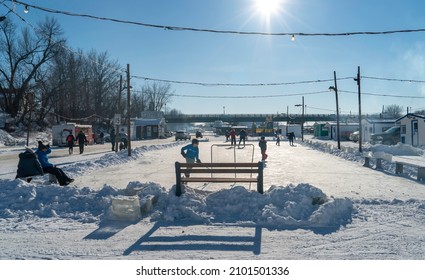 Saint Anne De La Parade, Quebec  Canada - December 29 2021: Kids Play Ice Hockey On The Frozen River Of Riviere Saint Anne In Quebec. The Rink Is Part Of An Ice Fishing Community.