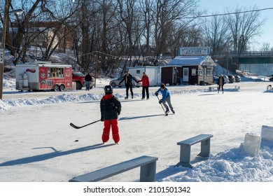 Saint Anne De La Parade, Quebec  Canada - December 29 2021: Kids Play Ice Hockey On The Frozen River Of Riviere Saint Anne In Quebec. The Rink Is Part Of An Ice Fishing Community.