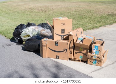 Saint Cloud, Florida / USA - September 23, 2019: Amazon Smile Delivery Boxes And Yard Waste At The Driveway Curb; For Garbage Pick Up  