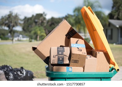 Saint Cloud, Florida / USA - September 23, 2019: Amazon Smile Delivery Boxes Waste At The Curb For Garbage Pick Up With Green And Yellow Recycle Bin