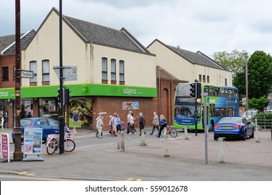 SAINT IVES, CAMBRIDGESHIRE, UK - CIRCA MAY 2016: Busy Town Center View Of A Popular Supermarket Seen On The Corner Of A Busy Crossing Area On A Typical Weekend.