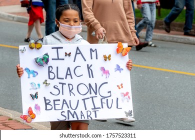 Saint John, NB, Canada - June 14, 2020: Black Lives Matter rally. A young black girl carries a sign "I AM BLACK STRONG BEAUTIFUL SMART".