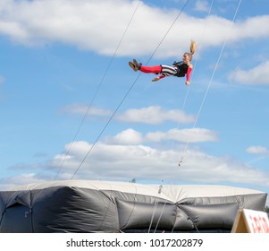 Saint John, New Brunswick, Canada - September 4, 2015: An acrobat performs at the Saint John Exhibition. She is falling towards a large airbag.