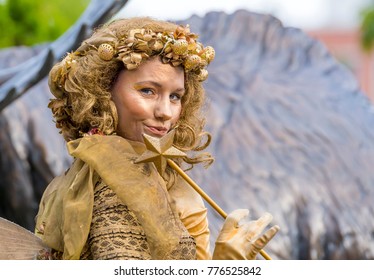 Saint John, New Brunswick, Canada - July 13, 2017: Annual Buskers On The Bay Festival. A woman dressed as a fairy, completely in gold and with gold makeup, with a wand.