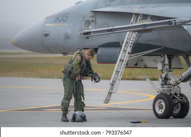 Saint John, New Brunswick, Canada - Setpember 17, 2017: A Female Fighter Pilot Preperes Her Flight Suit Standing Next To A CF-18 Hornet Fighter Jet.