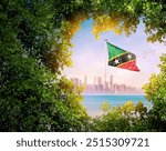 Saint Kitts and Nevis flag waving with modern skyline. A flag blow behind the tree leafs. Saint Kitts and Nevis national flag for independence day.