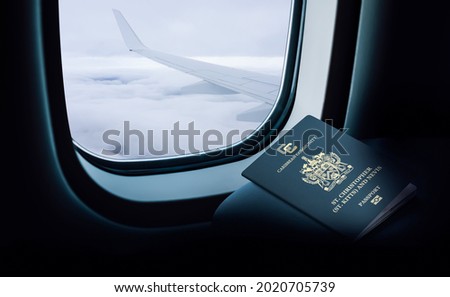Saint Kitts and Nevis passport on the plane in front of the window