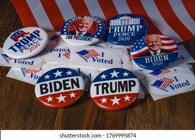 Saint Louis, MO--July 5, 2020; Biden Democrat And Trump Republican Presidential Campaign Buttons From 2020 Election Sit On Pile Of I Voted Stickers With American Flag In Lay Flat Collection