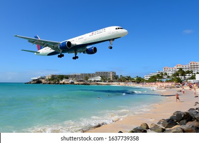 Saint Maarten / Dutch Antilles - January 12, 2016: Delta Airlines Boeing 757 about to land in St Maarten airport passing over Maho Beach, famous for the airplanes passing very low. Tourist attraction.