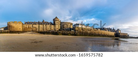 Saint Malo cityscape or skyline at dusk. Medieval ramparts surrounding the historic town from Plage de l'Eventail panoramic scenery, Brittany, France.