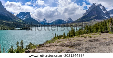 Saint Mary Lake at Sun Point - A panoramic overlook of Saint Mary Lake and its surrounding rugged high mountain peak at Sun Point on a stormy Spring afternoon. Glacier National Park, Montana, USA.