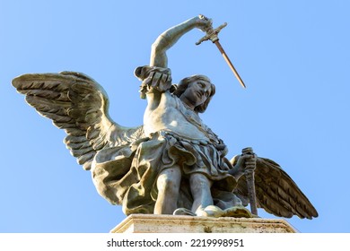 Saint Michael archangel statue at top of Castel Sant'Angelo, Rome, Italy. St Michael the Archangel with wings and sword on sky background. Old sculpture of archangel, angel, bronze monument close-up.