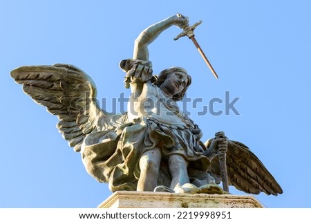 Saint Michael archangel statue at top of Castel Sant'Angelo, Rome, Italy. St Michael the Archangel with wings and sword on sky background. Old sculpture of archangel, angel, bronze monument close-up.