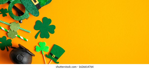 Saint Patrick's Day background with clovers shamrock symbols, Irish elf hats, pot, party drinking straws. Happy St. Patrick’s Day concept. Greeting card, party invitation template, banner mockup - Powered by Shutterstock