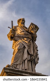 Saint Paul apostle statue holding a broken sword and a book on Ponte Sant Angelo bridge in Rome, Italy. Marble sculpture from 1464 by Paulo Romano at sunset