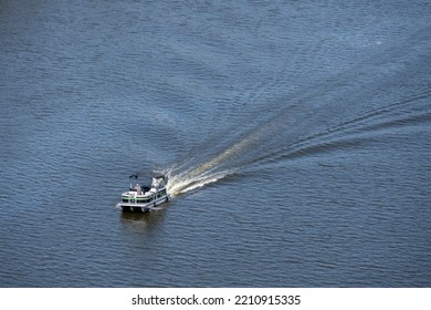 Saint Paul, MN - Sep 9 2022: A Single Pontoon Boat Sailing On The Mississippi River And Causing A Wake.