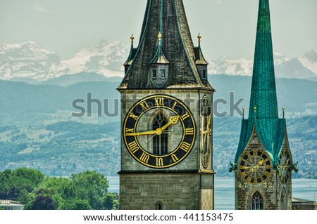 Saint Peter and FraumÃ¼nster Church in Zurich (Switzerland) in front of lake Zurich and the Swiss Alps, HDR-technique