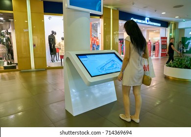 SAINT PETERSBURG, RUSSIA - CIRCA AUGUST, 2017: woman use information kiosk at Galeria shopping center. Galeria is major shopping and entertainment center is located in downtown of St. Petersburg