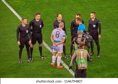 Saint Petersburg, Russia - February 22, 2018: Soccer Referee Flipping A Coint. Football Teams Captains Watching Coin Toss At The Pitch Before UEFA Europa League Match Game Zenit F.C. Vs Celtic FC 