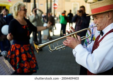 Saint Petersburg, Russian Federation - June 21, 2021: Older Man Playing Trumpet. Jazz Musician With Flugelhorn On Street Background. 