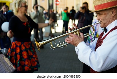 Saint Petersburg, Russian Federation - June 21, 2021: Older Man Playing Trumpet. Jazz Musician With Flugelhorn On Street Background. 