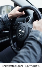 Saint Petersburg / Russia-October, 15, 2020: Confident Male Driver Holds The Steering Wheel Of A Mazda Car. Comfortable Driving Concept, Men's Hands Close-up, Vertical Photo