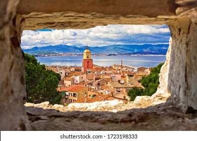 Saint Tropez village church tower and old rooftops view through stone window, famous tourist destination on Cote d Azur, Alpes-Maritimes department in southern France