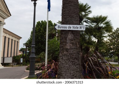 Saint-Laurent-du-Var, France - June 22, 2021: A Sign In The Shape Of An Arrow Nailed To A Palm Tree Indicates The Direction Of A Polling Station Near The City Hall