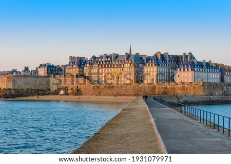 Saint-Malo, Brittany, France: View of the fortified old town, Intra-Muros, from the Môle Des Noires pier in the evening. 
