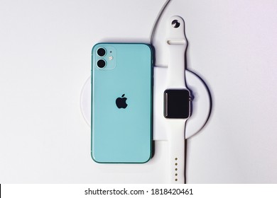 Saint-Petersburg, Russia - 09.09.20: Apple New Smartphone Green IPhone 11 Is Charging On Wireless Charger Together With Smartwatch Apple Watch