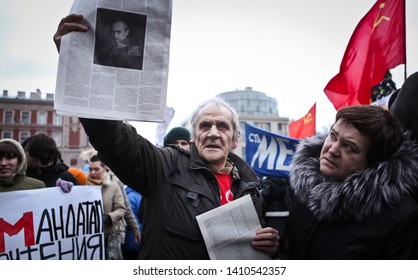 Saint-Petersburg Russia; 18.12.2011: old man with one eye blind holding document with russian president Putin portrait on demonstration against current goverment after recent parliament elections; 